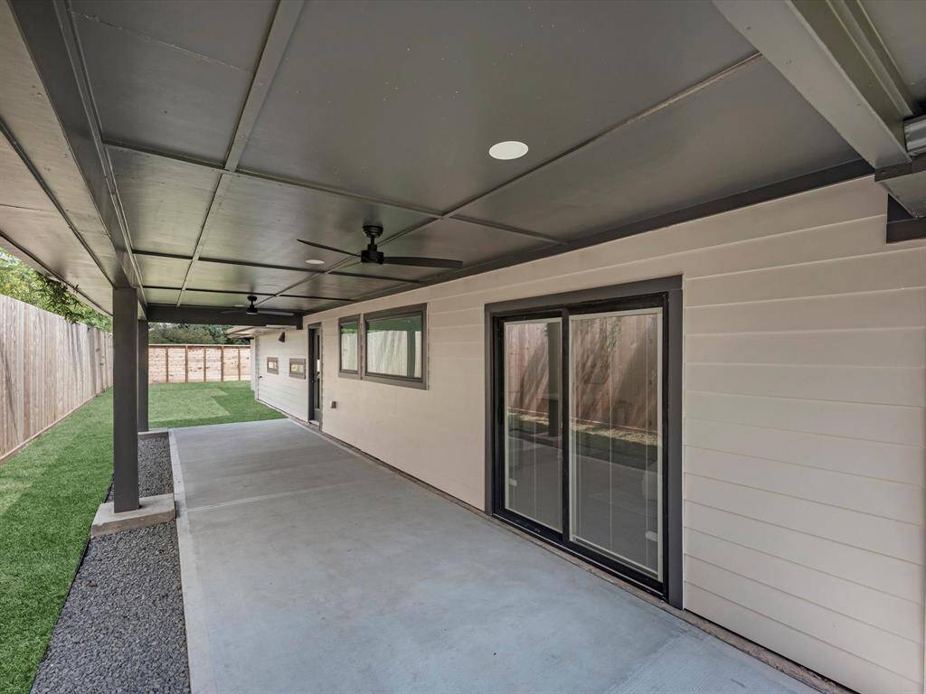 Large covered porch with ceiling fans and sliding door to the primary bedroom.