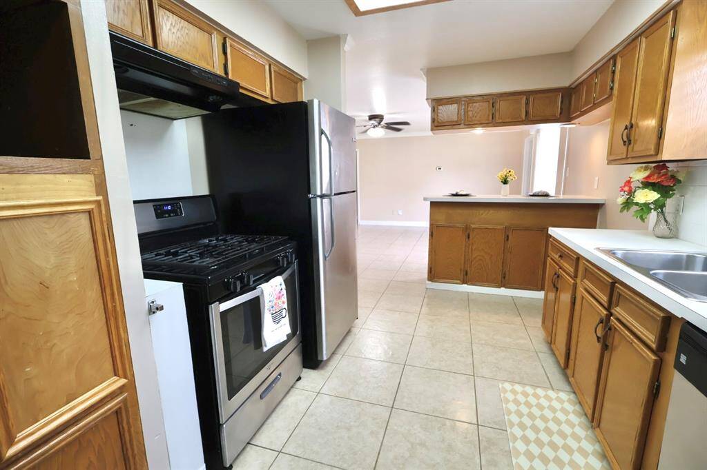 Bright and inviting kitchen showcasing stainless steel appliances paired with handcrafted wood cabinets, creating a warm yet contemporary space