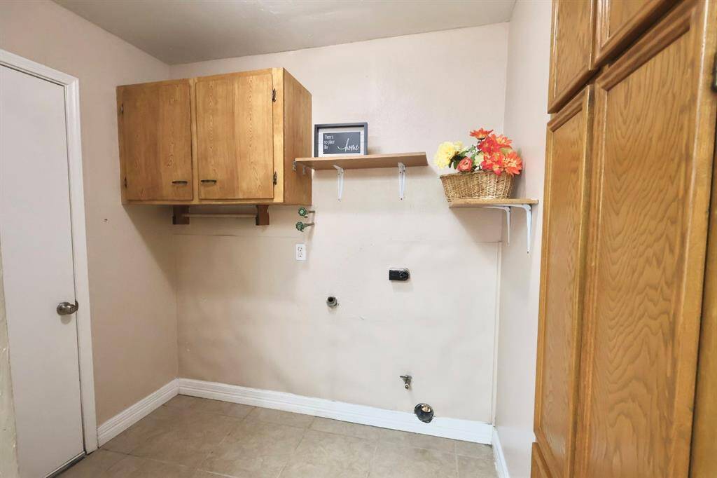 Convenient laundry room located just off the kitchen, featuring built-in cabinetry