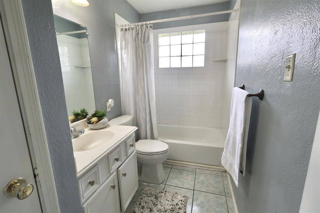 Light and serene bathroom with a classic tub/shower combo, complemented by soft tones and subtle textures for a calm, inviting atmosphere
