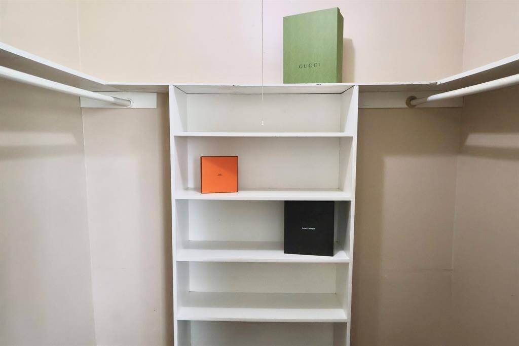 Spacious walk-in closet located in the primary bedroom, featuring built-in shelves for organized storage.