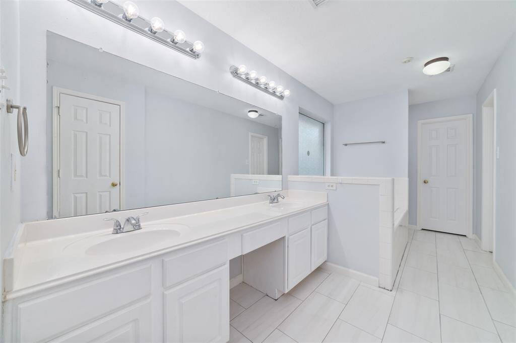 Primary bathroom with double vanities, large soaking tub and large walk in closet