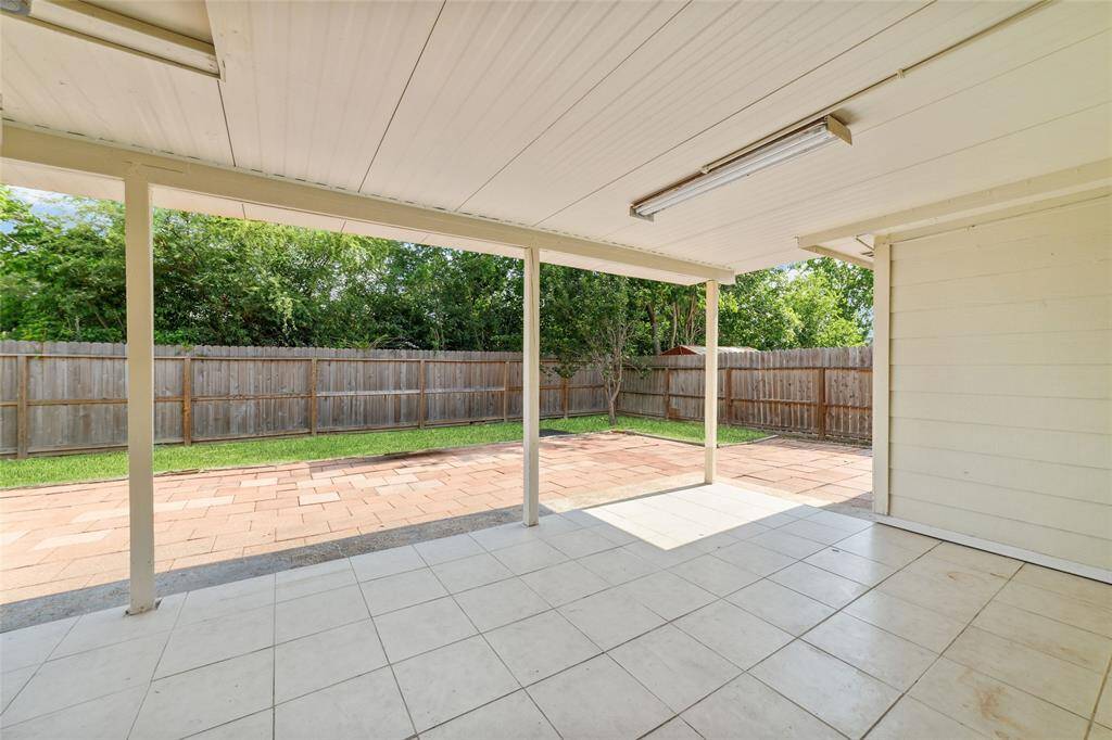Spacious extended covered patio with finished flooring and lighting