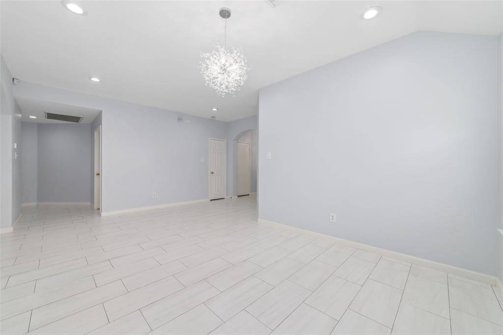 Extra large dining/living area with upgraded modern light fixtures and tile flooring