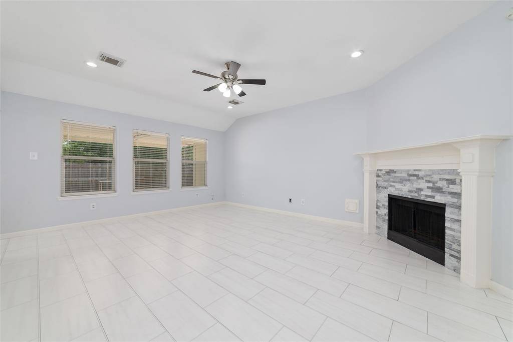 Open family room with raised ceiling and gas fireplace with updated fireplace surround