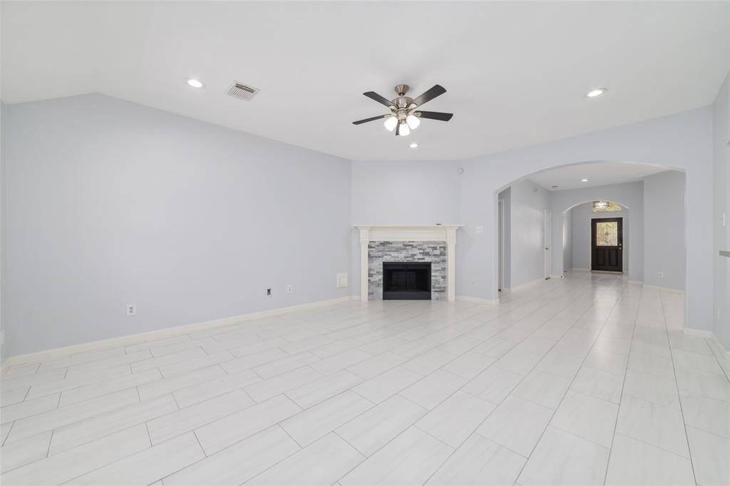 Spacious living room with open connections to dining/living room and arch opening details