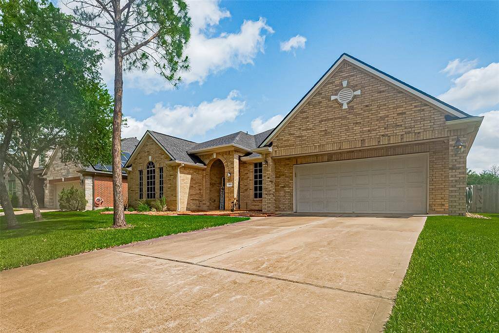 This Lennar built home with a swimming pool features a well-maintained lawn, a welcoming arched entryway, and a spacious driveway. Surrounded by mature trees, it offers inviting curb appeal and a peaceful setting.