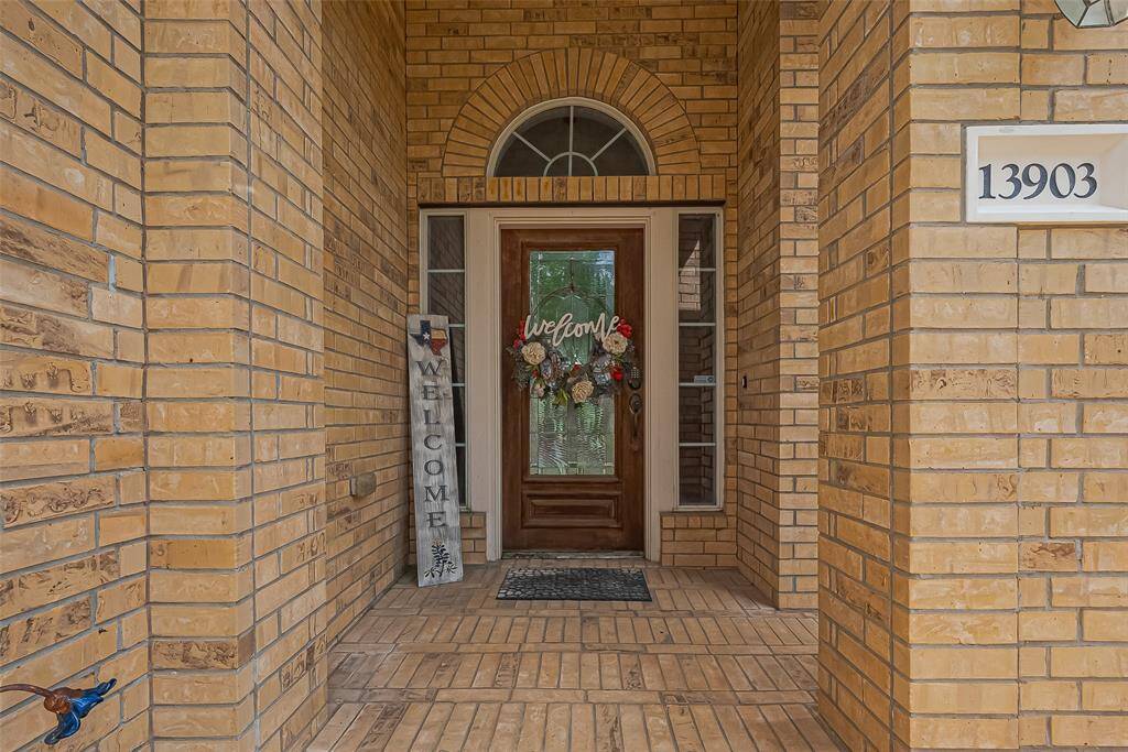 A welcoming brick entryway featuring a decorative glass door, flanked by sidelights and an arched transom window.