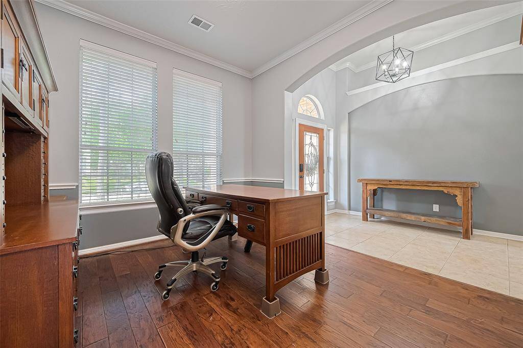 This photo showcases a bright flex space with large windows—perfect as a home office, formal dining, or second living area.