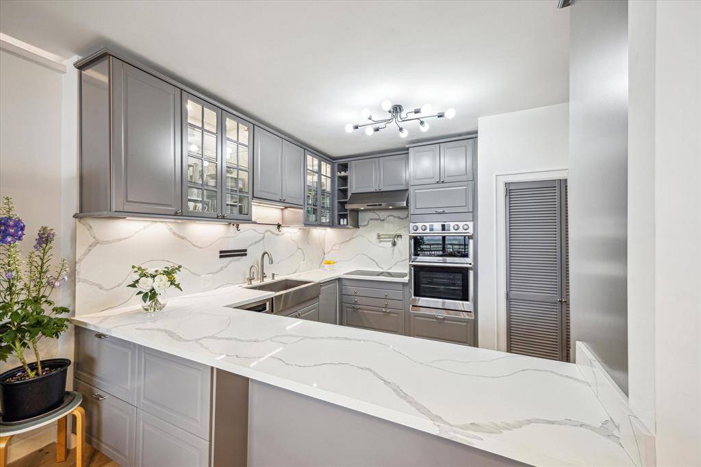 The gourmet kitchen, equipped with top-of-the-line appliances and a stunning breakfast bar, overlooks the living area, making it ideal for hosting gatherings.