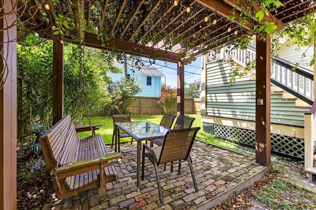 Seating area with pergola, luscious jasmine, original brick overlooking the expansive backyard.