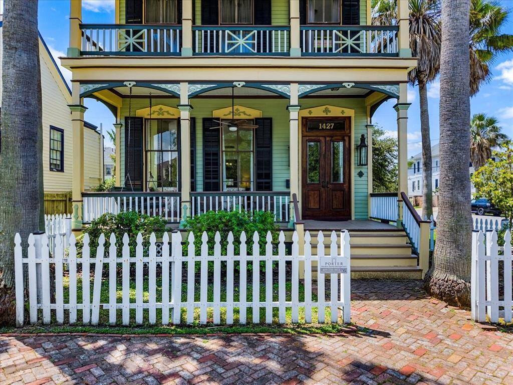 Gorgeous porch, detailed, ornate balconies, white picket fence and hand laid brick.