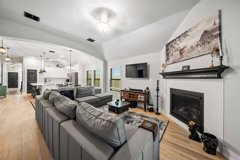 Fireplace has decorative tile surround adorned with a dark wood mantle