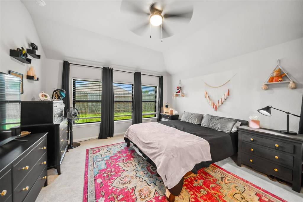 The primary bedroom is located in the back of the home and a wall of windows filter light in from the backyard.