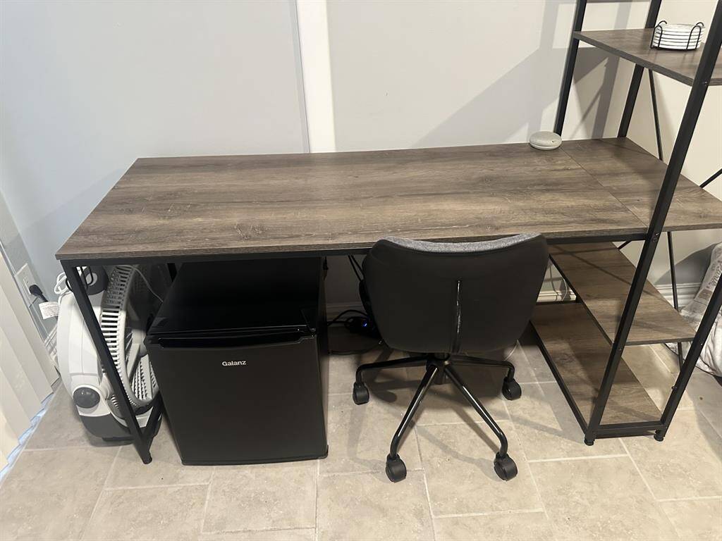 Loft bedroom has desk w/chair & small refrigerator
