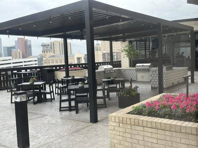 Outdoor kitchen area has 3 grills and lots of seating outside the inside social room and on terrace with more seating and pool area