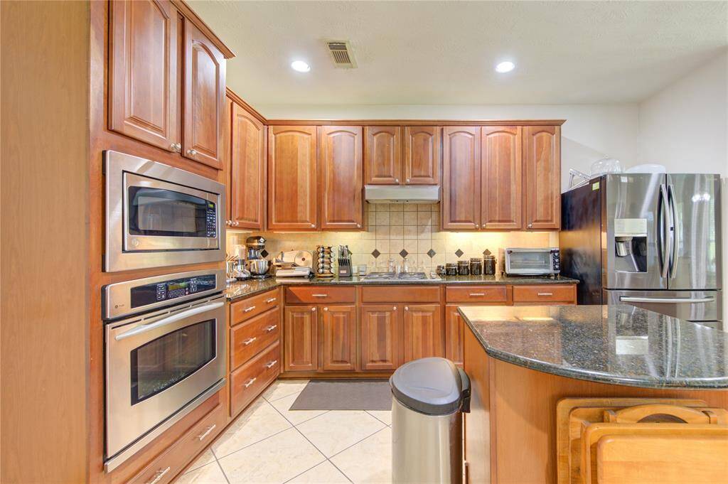 Kitchen boasts granite countertops, stainless steel appliances, and plenty of cabinet storage.