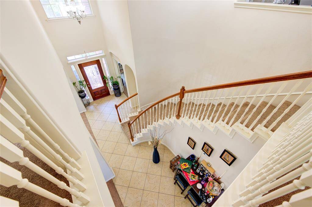Grand staircase with a beautiful curved design and tile inlay below.