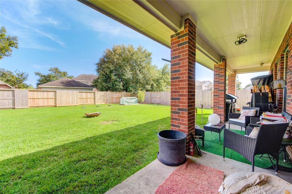 Second covered patio view with outdoor furniture and grill setup.