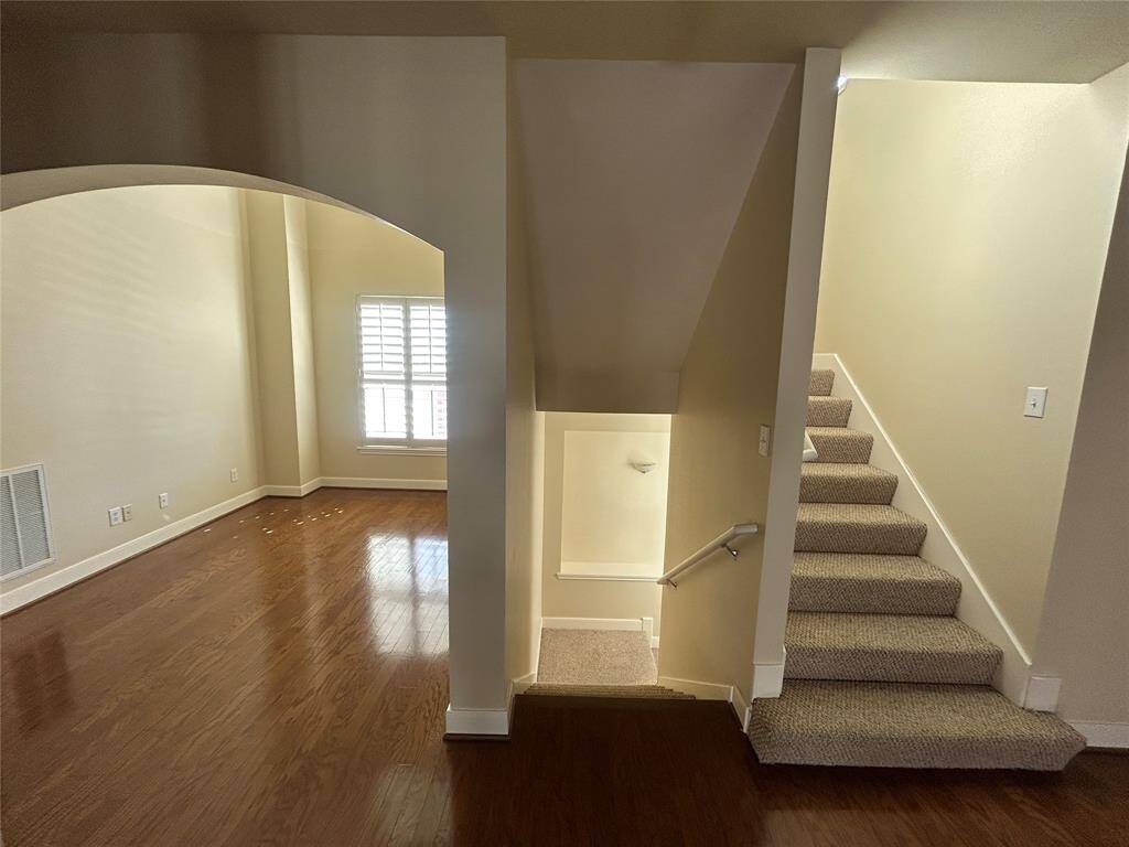 The entry stairwell features an elegant art niche and ample wall space—perfect for showcasing artwork or personal displays.