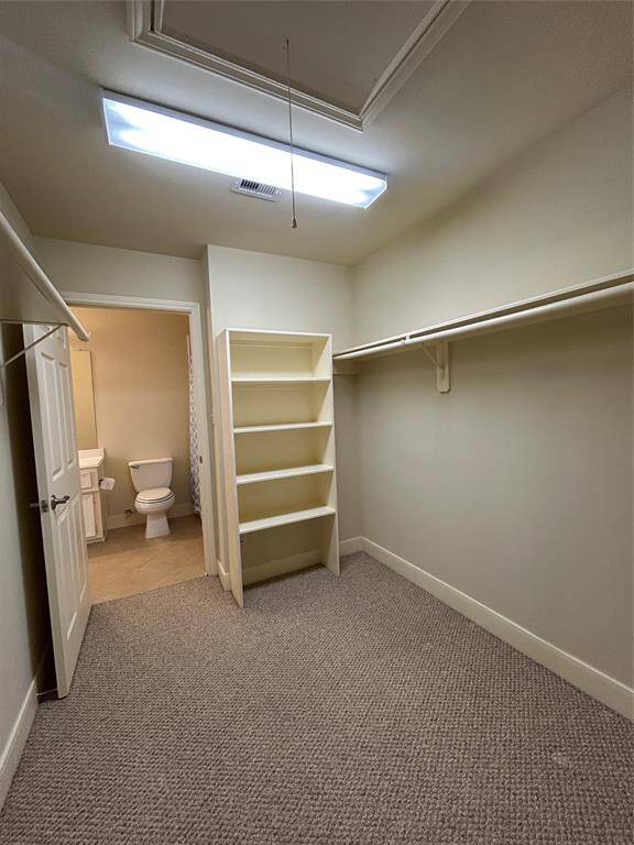 Expansive primary closet featuring custom built-in shelving and abundant storage space for effortless organization.