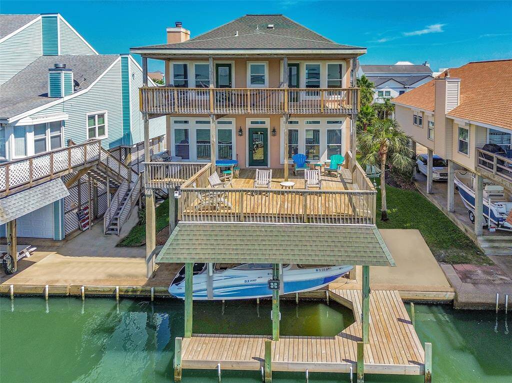 Bayfront home features two expansive decks, a covered boathouse with lift and slip, and patio furniture Included.