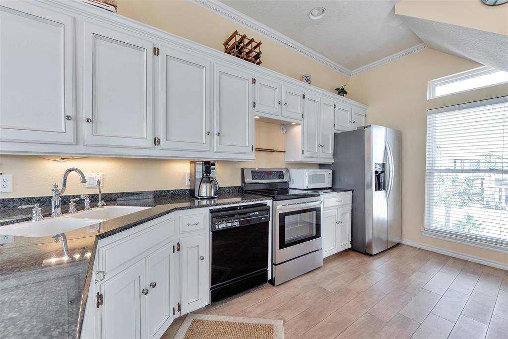 Coastal Kitchen Comfort – This bright and open kitchen includes stainless steel appliances, a convenient warming drawer, and a walk-in pantry.