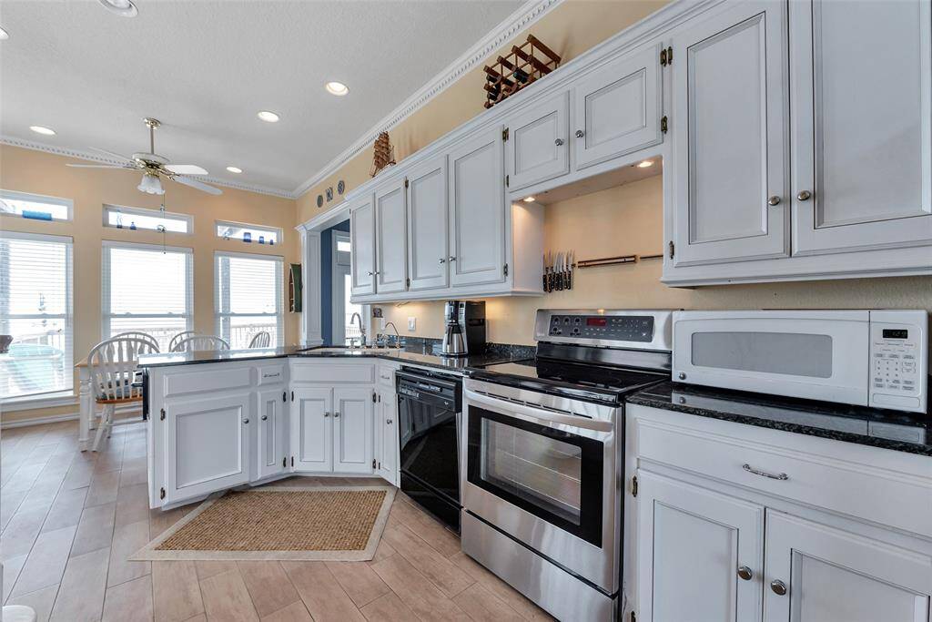 The kitchen layout keeps cooking essentials close at hand with upper and lower cabinet storage, built-in knife rack, and seamless flow to the dining area. Designed for both convenience and connection.