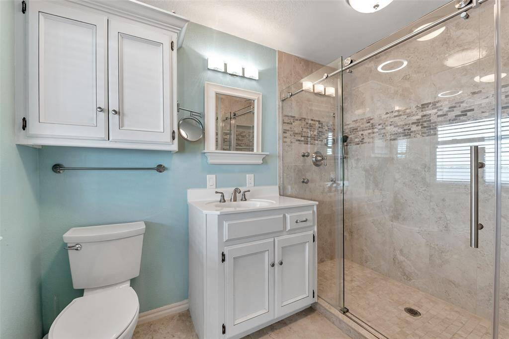 Enjoy the spa-like feel of this beautifully updated ensuite featuring a walk-in tile shower with glass enclosure, white vanity, and linen cabinetry for added storage. Clean lines and soft tones create a calming retreat.