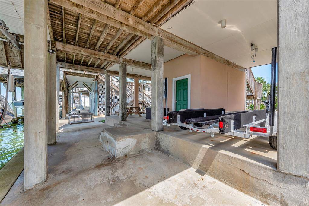 Underneath the home, you'll find a spacious covered deck and carport area that’s perfect for staying cool in the shade. There’s room for a trailer, seating, and easy access to the dock.