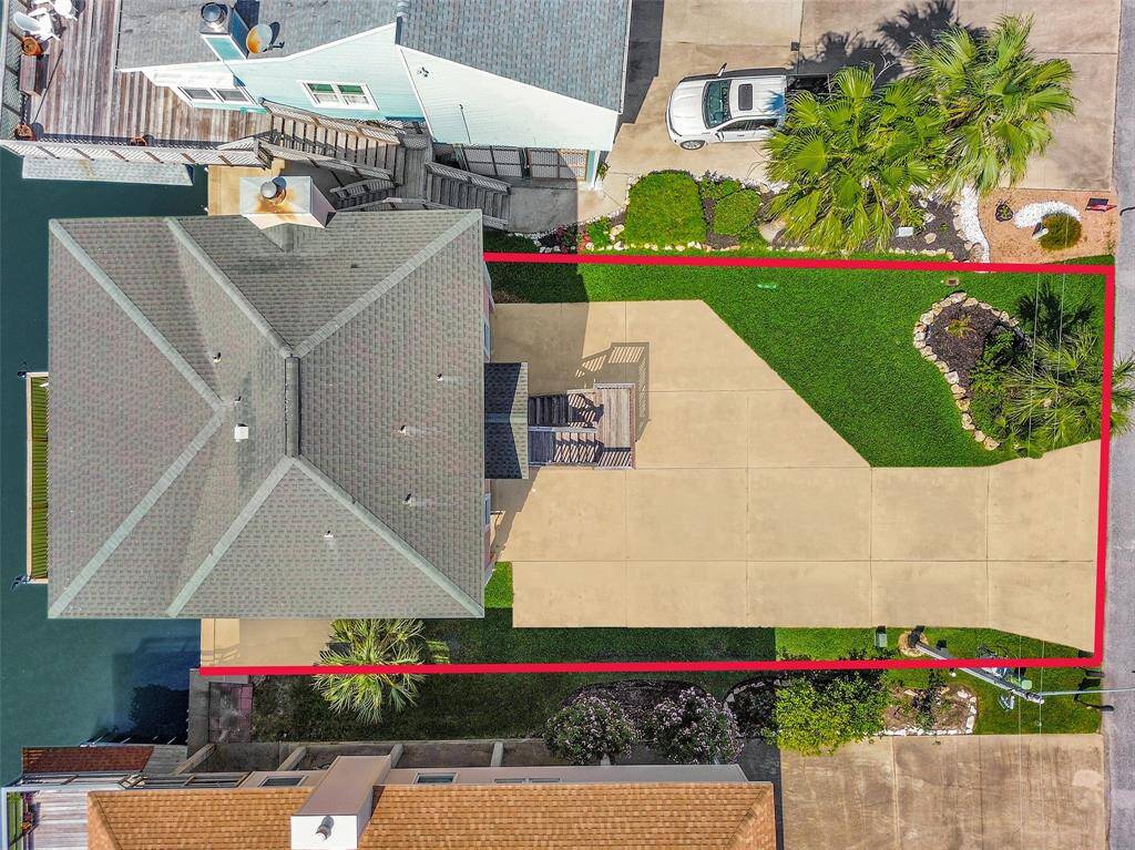 Bird’s-eye view of the full lot shows off the home’s footprint, spacious driveway, and beautifully landscaped yard.