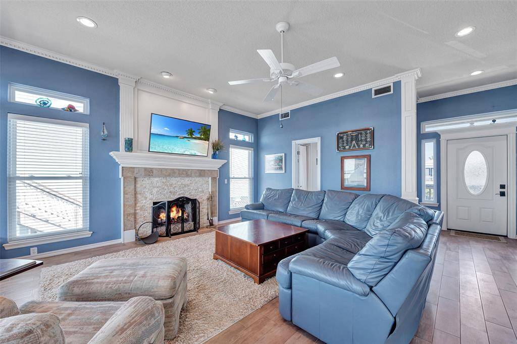 This inviting living area features soft recessed lighting, a beautifully tiled fireplace with a custom mantle, and space to gather or unwind.
