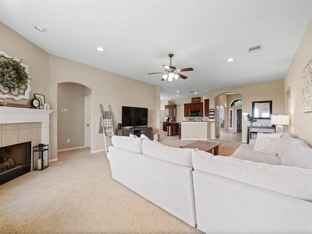 Bright and airy living room that is open to the kitchen and has a cozy fireplace.