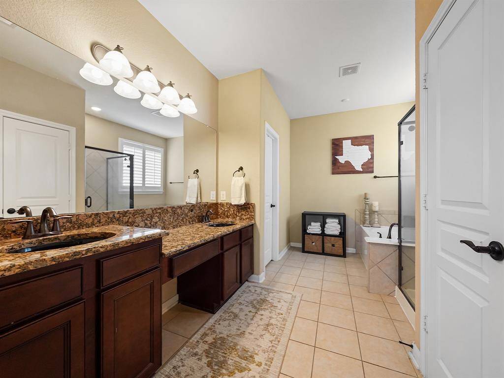 This primary ensuite comes complete with granite counters, dual sinks, a vanity, soaking tub and a walk in shower.
