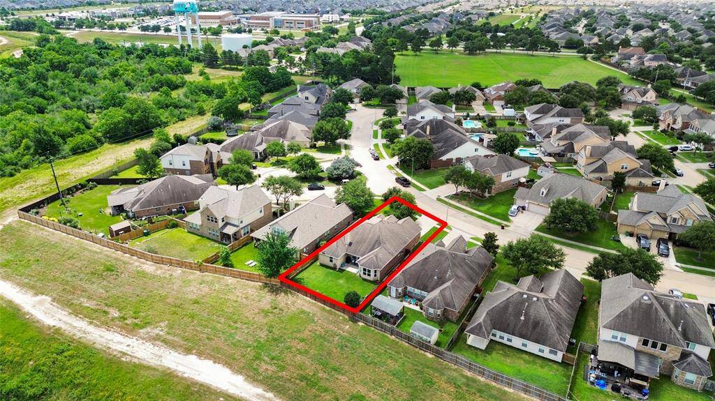 The property features a fenced yard with lush greenery and open spaces nearby, offering a serene living environment.