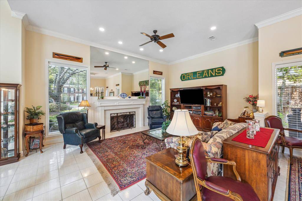 The family room has a large wood-burning fireplace (equipped with gas logs) that has a custom stone surround, custom wooden mantle and mantle-to-ceiling mirror. Windows at each side of the fireplace overlook the front lawn.