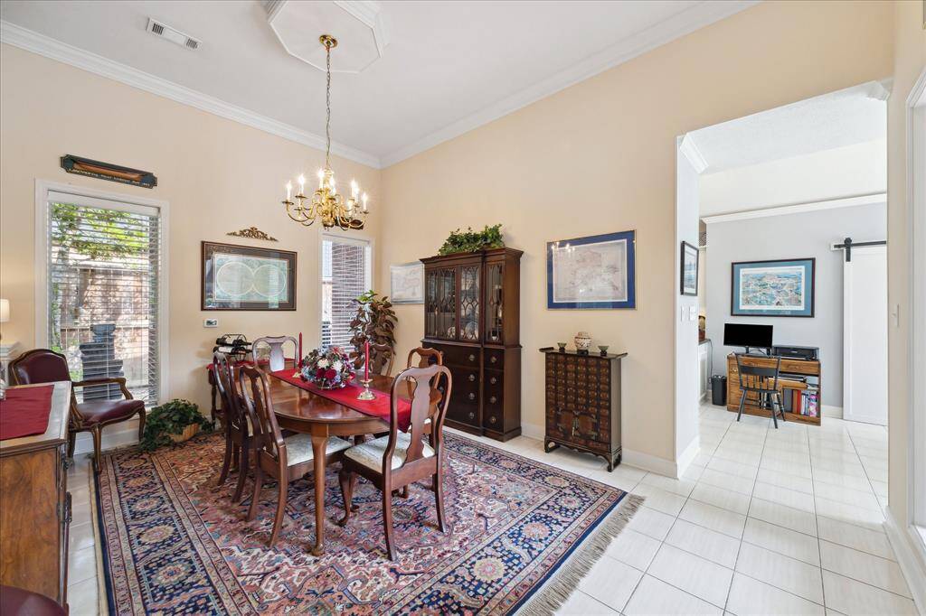 The formal dining room is open to the family room, has double windows overlooking the side yard, ceramic tile floor, high ceiling and crown molding trim.