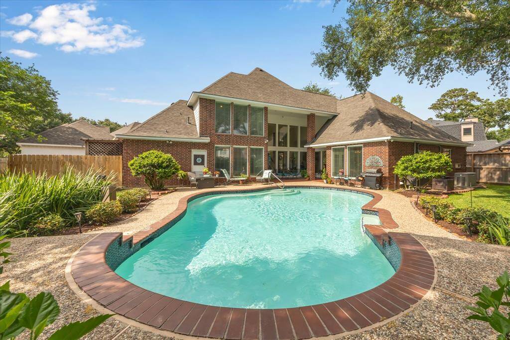 The large cul-de-sac lot provides room for a large in-ground pool that is surrounded by lush landscaping.