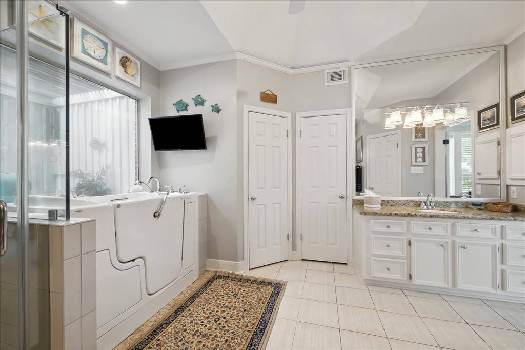 The primary bath bath features a walk-in tub accented with a large window.