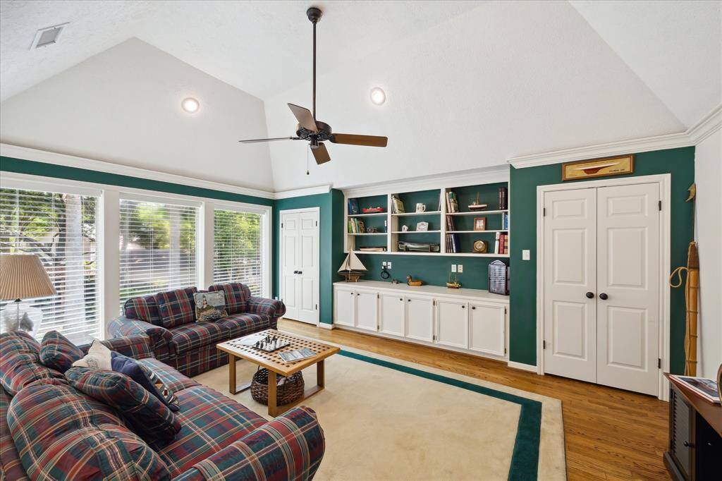 The upper level gameroom has built-in shelving with lower level cabinet storage and double reach-in closets. A vaulted ceiling with recessed lighting are features of this room.