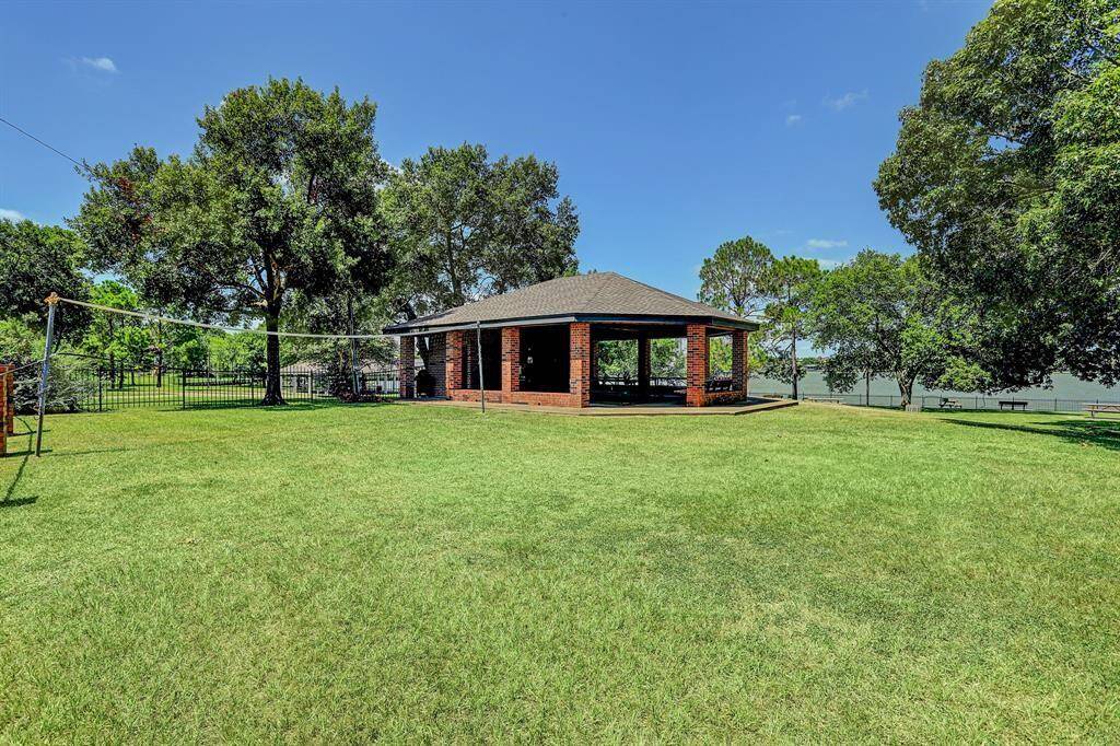 The Taylorcrest community park includes a large green area with volleyball net and a covered pavilion overlooking Taylor Lake.