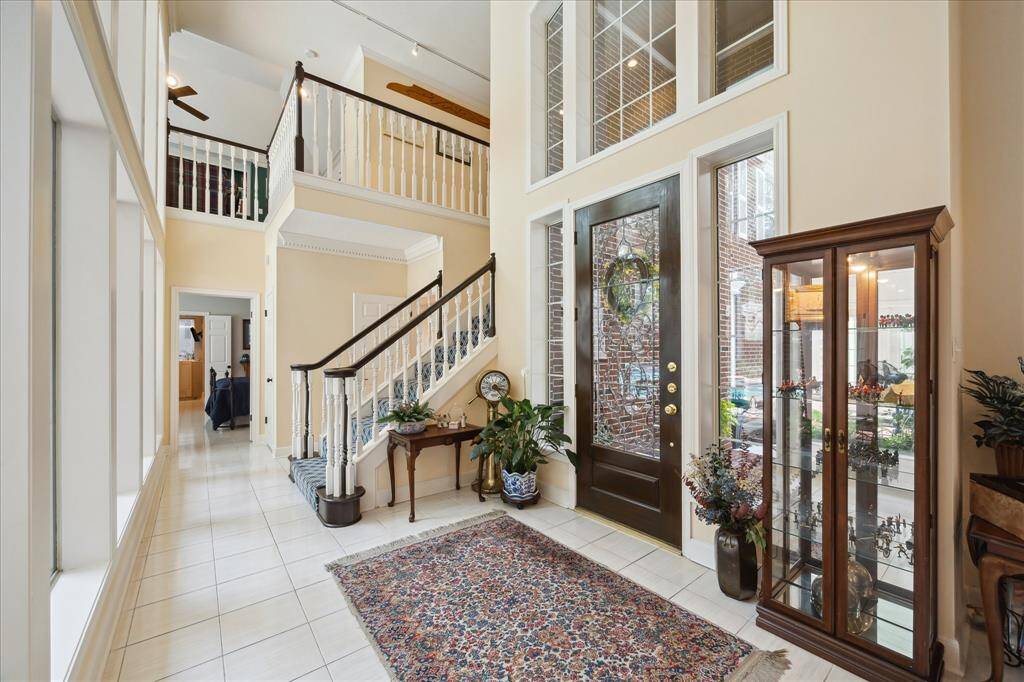 The light-bright entry has ceramic tile floor, and leads to a wall of windows (at the left of this photo) that overlooks the patio, pool and yard. The stairs at the rear of this photo lead to the upper level gameroom, 2 bedrooms and a full bathroom.