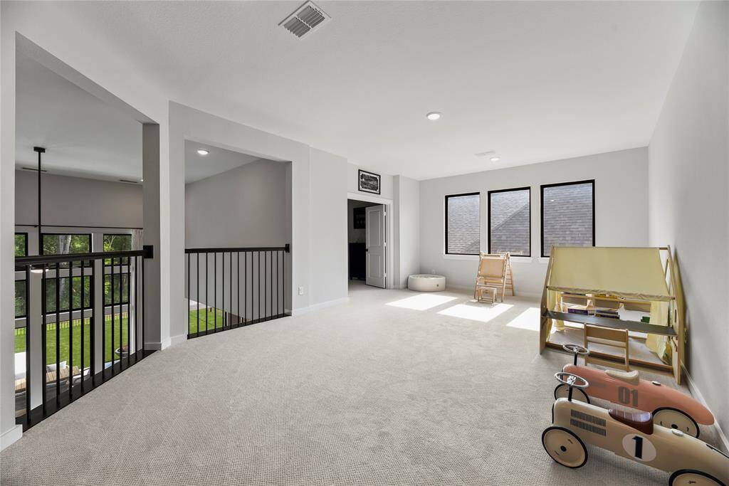 At the top of the stairs is a large game room overlooking the two story family room below.