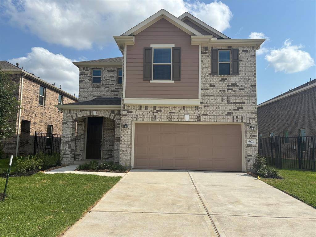 Modern two-story brick home with a double garage and a well-maintained front yard. Features include a covered entryway and charming upper-level shutters. Ideal for families seeking a comfortable suburban setting.