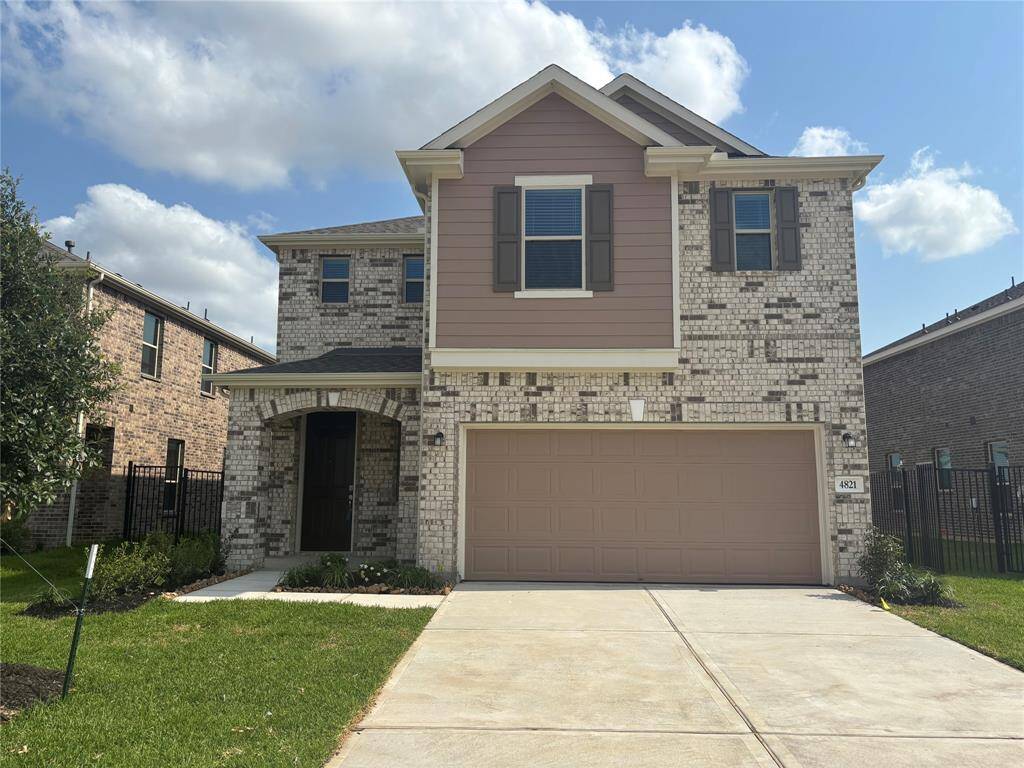 This is a modern two-story brick and siding home with a two-car garage and a small front porch. It features a well-maintained lawn and is located in a suburban neighborhood of Sunterra.