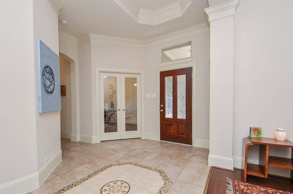 Simplicity is the key to gentle luxury wherever you look in this special residence. Here's the view, from the inside, of the front entrance; bright foyer and detailed tile flooring.