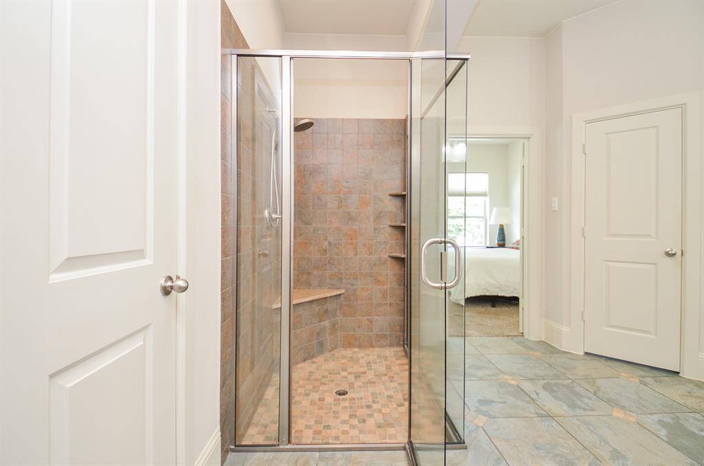 It's a clear view from this large walk-in, glass enclosed shower in the primary ensuite bath, to the bedroom, right.