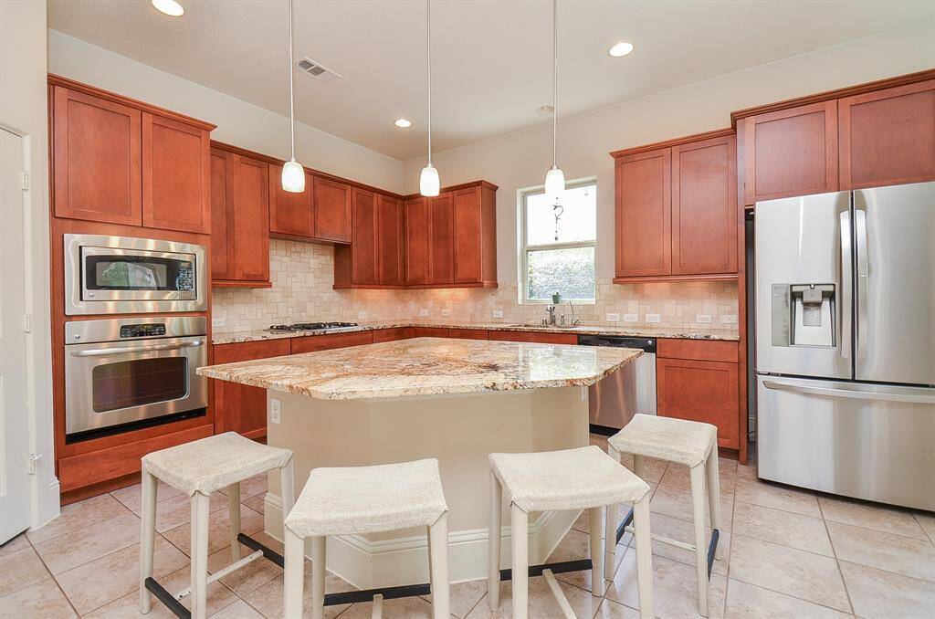 This scene can most likely become 'family central' for meeting and eating on weeknights and catching up time. Stainless steel appliances add to the glow of the space.