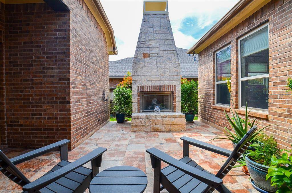 How divine is this hidden gem outdoor patio/courtyard, with gorgeous brick/stone enclosed fireplace?