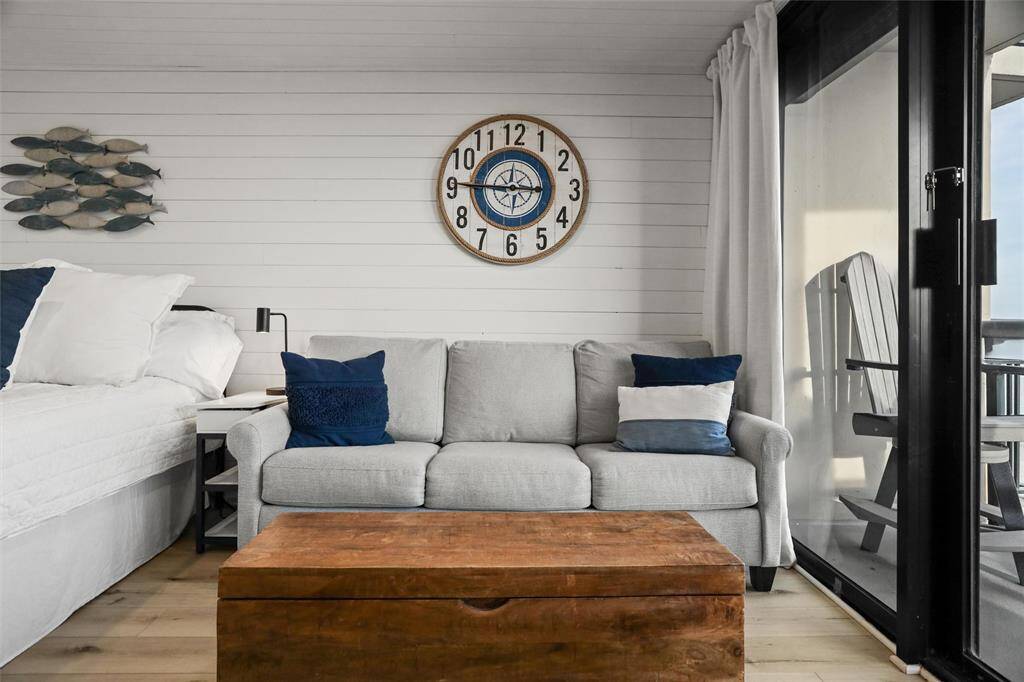 Comfortable queen sleeper sofa, a wooden trunk coffee table for added storage, enhanced by the custom white shiplap walls.